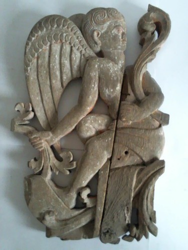Bilinski, Eva Halina - Skulptur: Sitzender Engel mit Pflanzenranken in Hand und Arm - Holzrelief in zwei Teilen mit Resten von roter und weier Fassung
