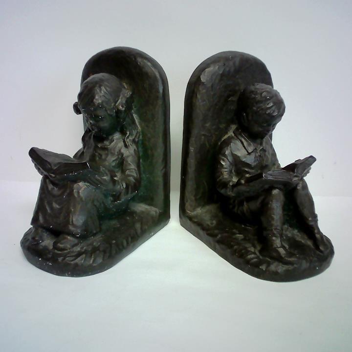 (Buchsttzen) - 2 Buchsttzen aus Kunststein in Bronze-Optik - Ein Mdchen und ein Junge, sitzend beim Lesen, je mit aufgeschlagenem Buch auf den Kien