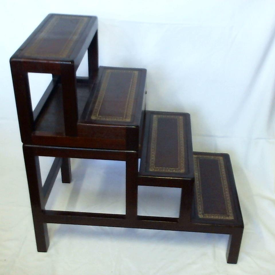 Vierstufiger Holzklapphocker, nußbaumfarben mit dunkelbraunen Leder-Stufenbezügen, diese mit goldgeprägter, floraler Bordüre